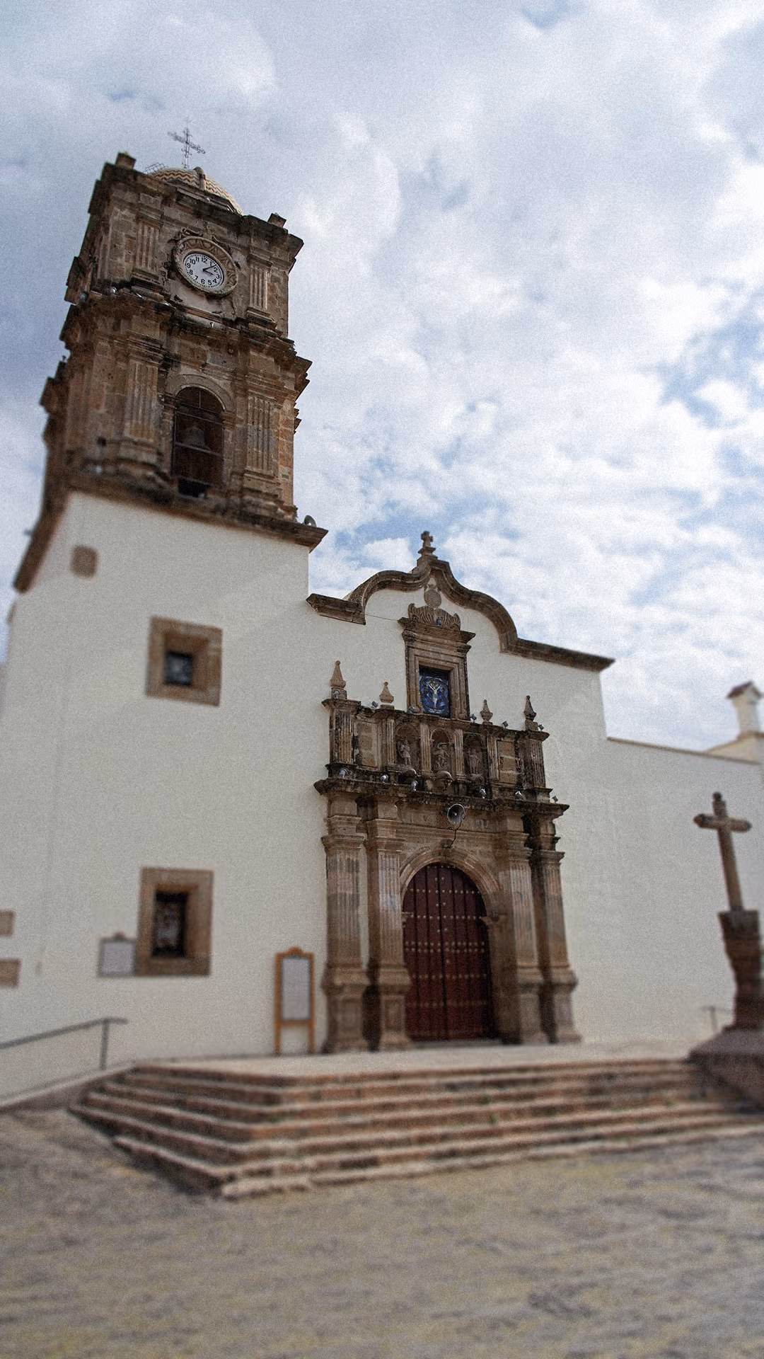 Fachada de una iglesia de piedra y muros blancos en Amatitán.