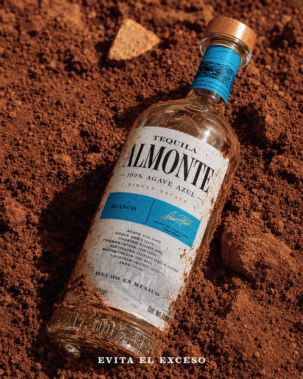 Botella de Almonte Blanco sobre tierra rojiza.